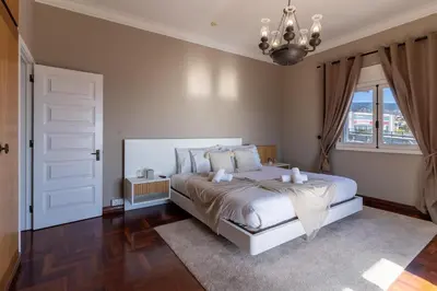 a bedroom with a white bed and a window at Só Espeto Accommodation Rooms in Santa Cruz