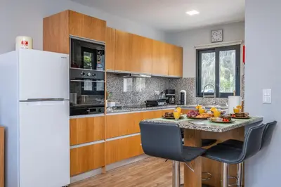 a kitchen with a table and a refrigerator at Salsa Country House II in Porto Moniz