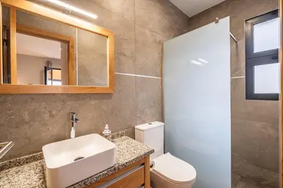 a bathroom with a sink and a toilet and a mirror at Salsa Country House II in Porto Moniz