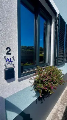 a window with a plant on the side of a building at Anastacio Tiny House in Porto Moniz