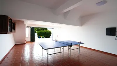 a ping pong table in the middle of a room at NostraCasa by LovelyStay in Caniço
