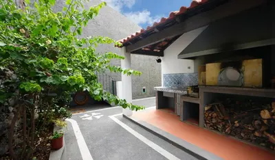 a courtyard with a pizza oven in a house at NostraCasa by LovelyStay in Caniço