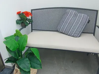 a white bench with a pillow and two plants at Holiday House Caetano in Ponta do Sol