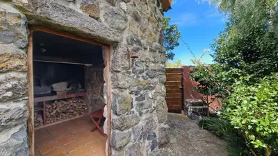 a stone building with a fireplace in a yard at Garden of Eden by LovelyStay in Ponta Delgada