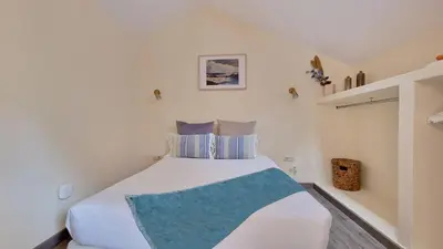 a bedroom with a large white bed with blue pillows at Garden of Eden by LovelyStay in Ponta Delgada