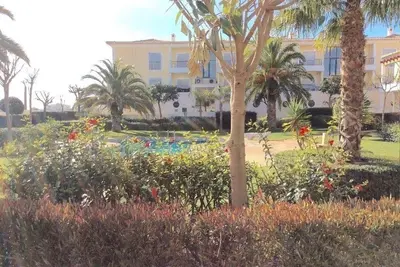 a resort with a garden with palm trees and a building at Casa Ella in Lagos
