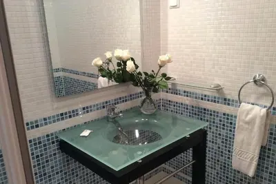 a bathroom with a sink with a vase of flowers at Casa Ella in Lagos