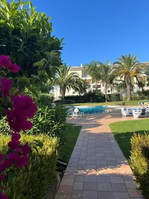 a resort with a swimming pool and palm trees at Casa Ella in Lagos