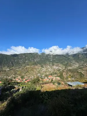 a view of a town on a mountain with clouds at Casa Gonçalves in São Vicente