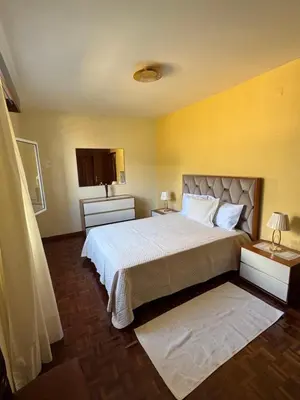 a bedroom with a large bed and a yellow wall at Casa Gonçalves in São Vicente