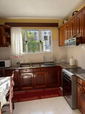 a kitchen with wooden cabinets and a sink and a window at Casa Gonçalves in São Vicente
