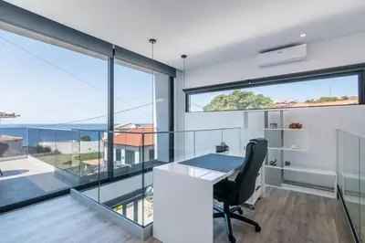 an office with a desk and large glass windows at CasaMar in Jardim do Mar