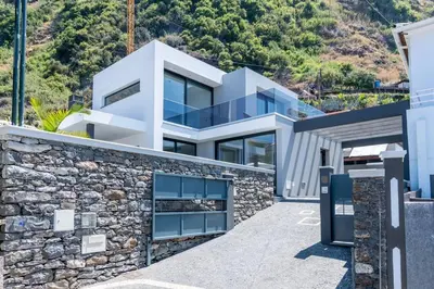 a white house with a stone wall at CasaMar in Jardim do Mar