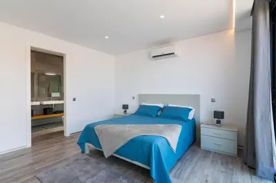a bedroom with a blue bed in a white room at CasaMar in Jardim do Mar