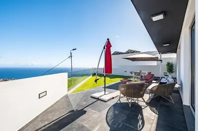 a balcony with a table and chairs and the ocean at Bayview Villa Retreat in Funchal