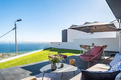a patio with a table and chairs and a view of the ocean at Bayview Villa Retreat in Funchal