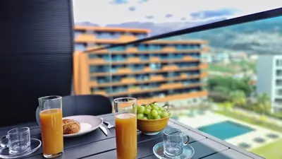 a table with two glasses of orange juice and a plate of fruit at Lux Suite by LovelyStay in Funchal