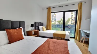 a hotel room with two beds and a large window at Lux Suite by LovelyStay in Funchal