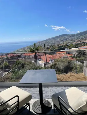 a balcony with a table and chairs and the ocean at The Vibe Madeira Apartment 2 in Arco da Calheta