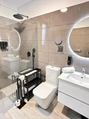 a bathroom with a white toilet and a sink at The Vibe Madeira Apartment 2 in Arco da Calheta