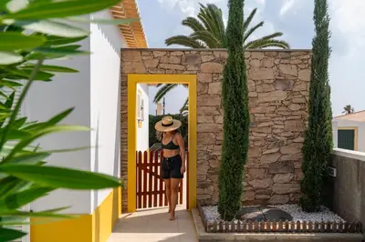 a woman in a hat walking through a doorway at Casa da Graça by An Island Apart in Porto Santo