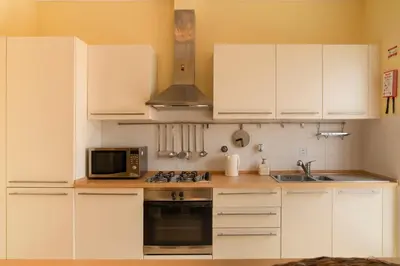 a kitchen with white cabinets and a microwave at Casa da Graça by An Island Apart in Porto Santo