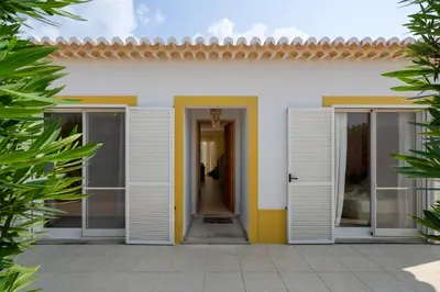 a white house with white doors and a hallway at Casa da Graça by An Island Apart in Porto Santo