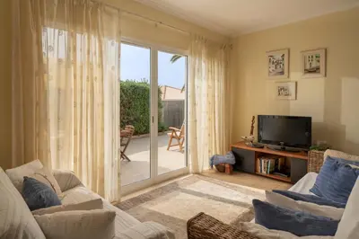 a living room with a television and a sliding glass door at Casa da Graça by An Island Apart in Porto Santo