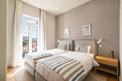 a bedroom with two beds and a large window at Luxury Retreat in Camara de Lobos in Câmara de Lobos