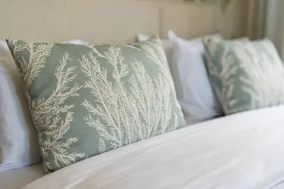 a group of pillows sitting on top of a bed at Luxury Retreat in Camara de Lobos in Câmara de Lobos