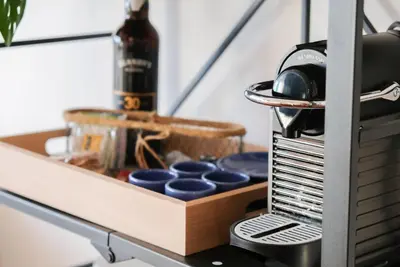 a drawer in a kitchen with blue dishes and a bottle at Funchal Sunset Apartment in Funchal