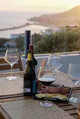 a table with two glasses of wine and a plate of food at Funchal Sunset Apartment in Funchal