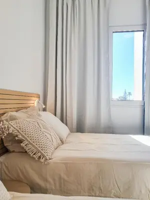 a bed in a white room with a window at Funchal Sunset Apartment in Funchal