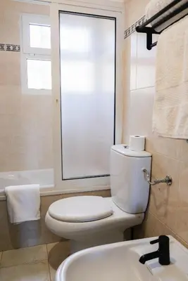 a bathroom with a toilet and a sink and a tub at Funchal Sunset Apartment in Funchal