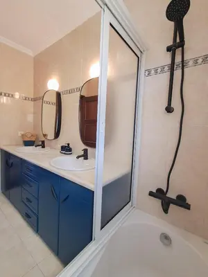 a bathroom with two sinks and a shower at Funchal Sunset Apartment in Funchal