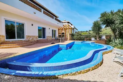 a swimming pool in the backyard of a villa at Lovely hugh villa close to beaches up to 10 sleeps in Hortas do Tabual