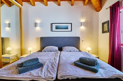 a bedroom with a bed with two pillows on it at Lovely hugh villa close to beaches up to 10 sleeps in Hortas do Tabual