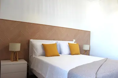 a bedroom with a large bed with two yellow pillows at Madeira Home Spacious Accommodation in Funchal