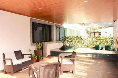 a patio with chairs and a table and a bench at Madeira Home Spacious Accommodation in Funchal