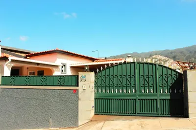 a green gate in front of a house at Madeira Home Spacious Accommodation in Funchal