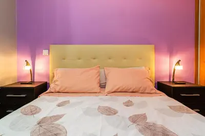 a bedroom with a bed and a wooden door at Green Doors - AC and free parking in Machico