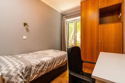 a dining room with a table and chairs and a kitchen at Green Doors - AC and free parking in Machico