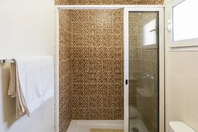 a shower with a glass door in a bathroom at Green Doors - AC and free parking in Machico
