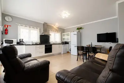 a kitchen and a living room with a couch and a table at Green Doors - AC and free parking in Machico