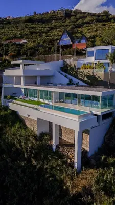 a large white building with a swimming pool at Villa Gia in Calheta