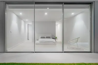 a glass room with a bed and a chair at Villa Gia in Calheta
