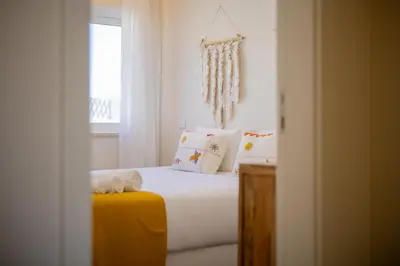 a bedroom with a bed with white sheets and pillows at Pontalaia Atlantic View in Sagres