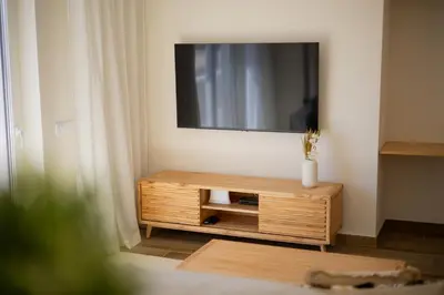 a living room with a tv and a wooden cabinet at Pontalaia Atlantic View in Sagres