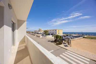 a balcony with a view of a street and the ocean at Pontalaia Ocean View in Sagres