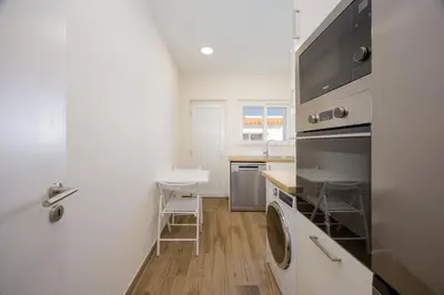 a white kitchen with a washer and dryer in it at Pontalaia Ocean View in Sagres